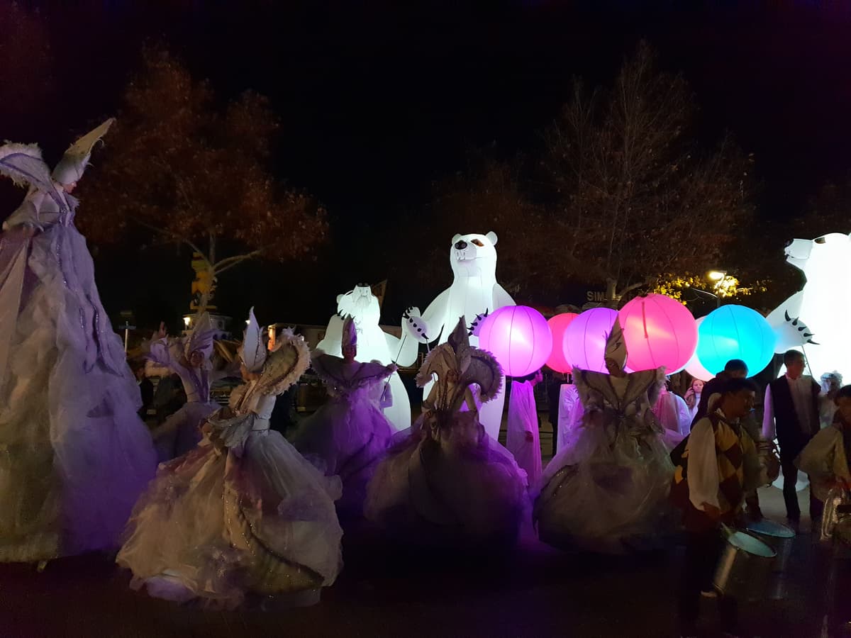 Osos polares iluminados junto a esferas de colores en el cortejo nocturno de una cabalgata de Reyes