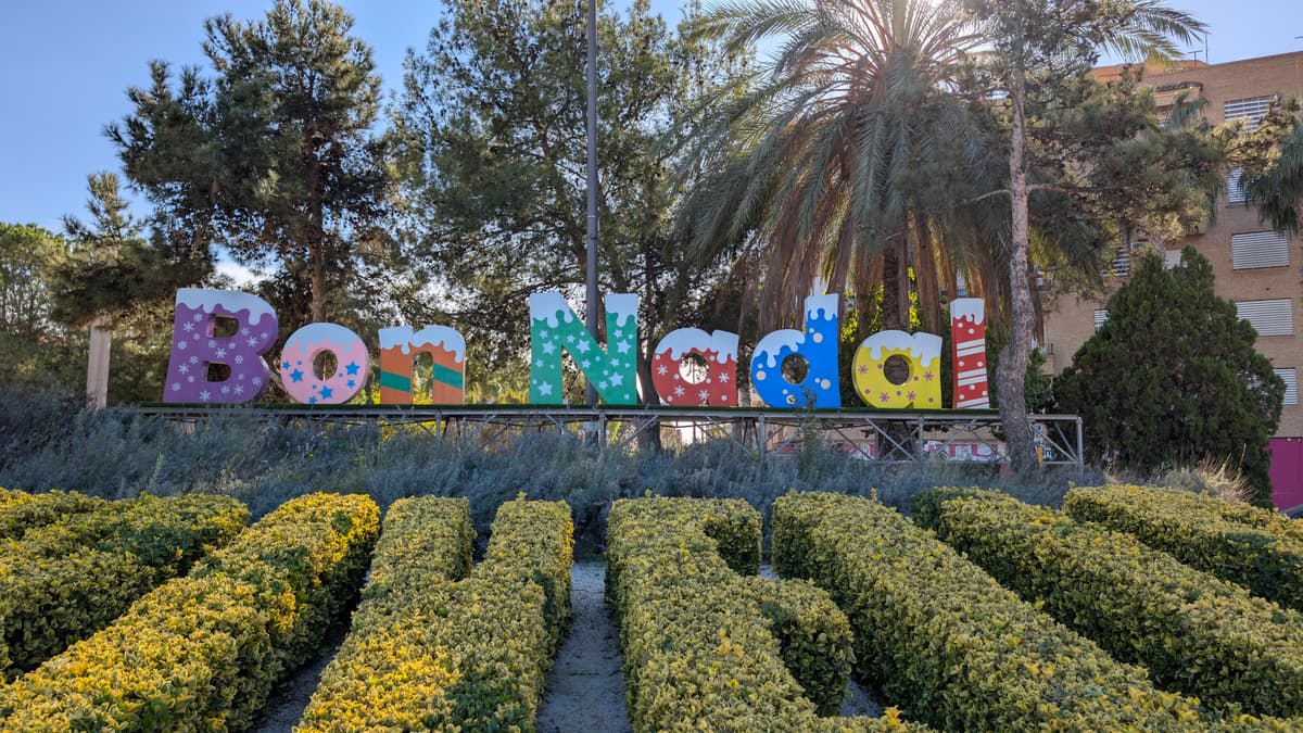 Letras navideñas de gran formato instaladas en un jardín durante el día