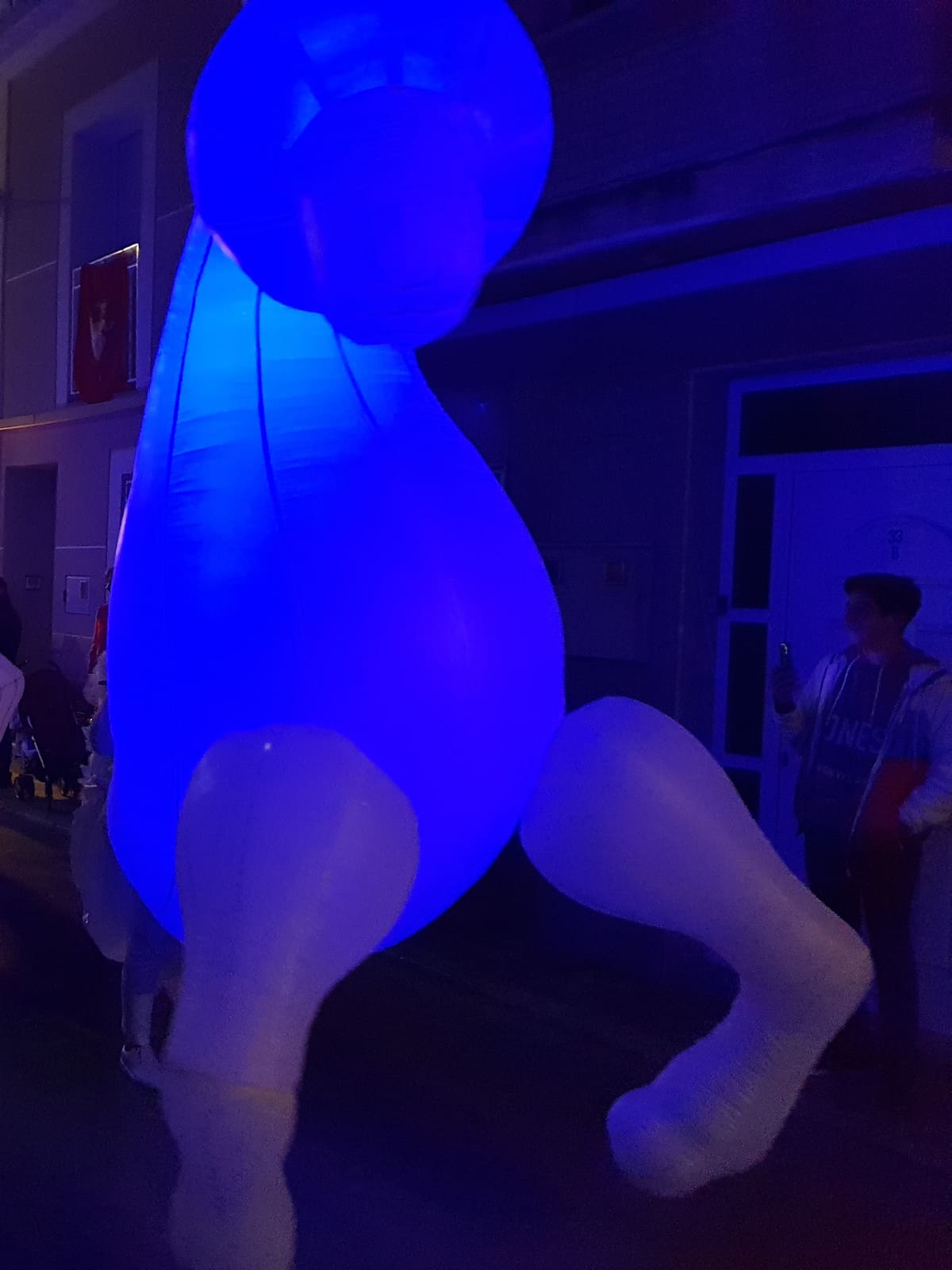 Caballos hinchables iluminados en azul en cabalgata de Reyes nocturna por calle estrecha